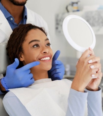 Dental patient admiring her smile in a mirror