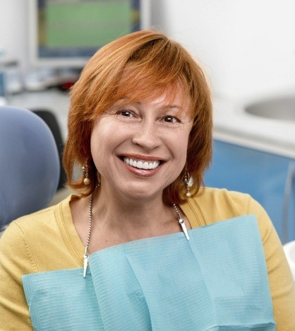 Woman with red hair grinning in dental chair