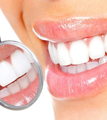 Close up of smile with white teeth next to dental mirror
