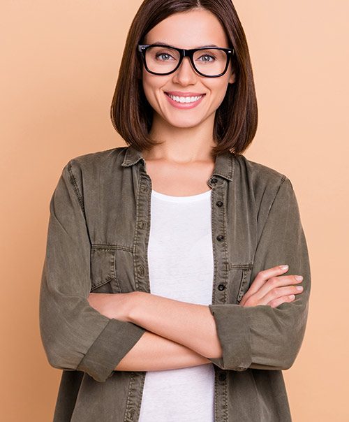 Smiling woman with glasses and crossed arms, a LAPIP laser gum patient at Lux Smiles in New York