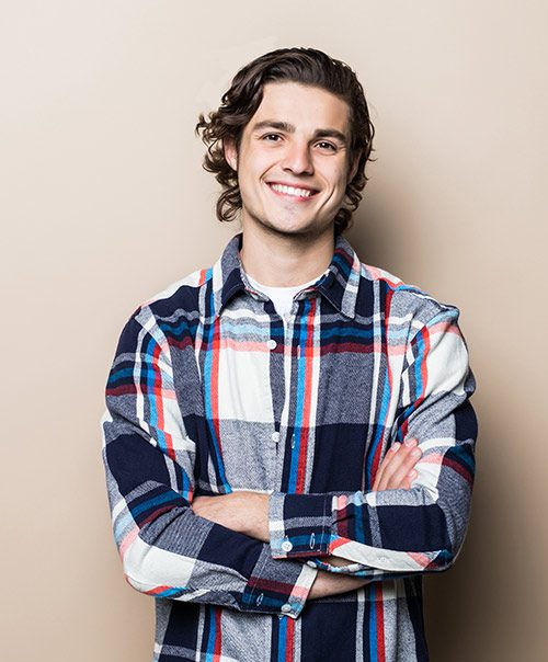 Smiling young man with arms crossed after dental fillings at our New York clinic in Gramercy Park