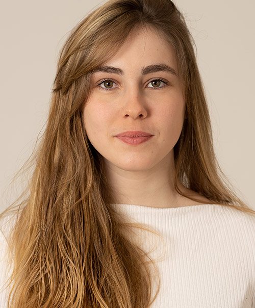 Woman with long brown hair smiling gently, a patient at our Union Square oral surgeon NYC practice