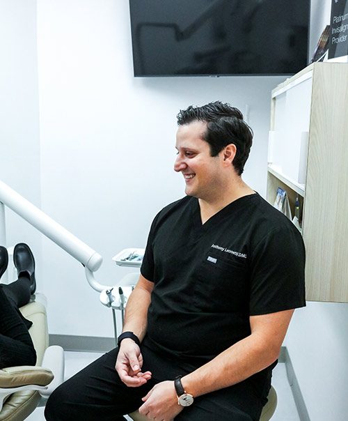 Dr. Anthony Leonetti smiling in a treatment room at Lux Smiles NYC dentures clinic in New York