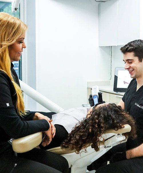 Periodontist and hygienist comforting a patient during gum disease treatment at Lux Smiles in New York